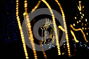 Christmas gifts and horse decorated with vertical curtains of multi-colored round lights.