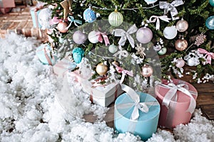 Christmas gifts packed with pink,tiffany paper and tapes under decorated tree.