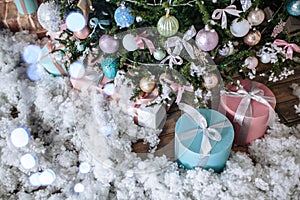 Christmas gifts packed with pink,tiffany paper and tapes under decorated tree. Copy space