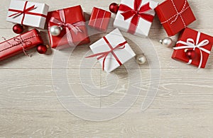 Christmas gifts presents on rustic wood background. Simple, red and white gift boxes festive holiday border.