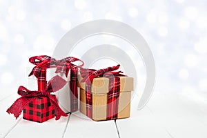 Christmas gifts with red plaid pattern ribbon and twinkling silver light background