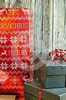 Christmas gifts with red ribbon on table and wood background