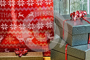 Christmas gifts with red ribbon on table and wood background