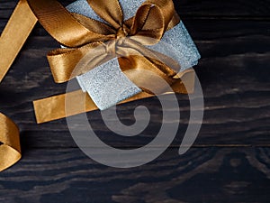 Christmas gifts on the wooden background, Christmas Present with Gold Ribbon and Gold Christmas Decorations. Rustic Background.