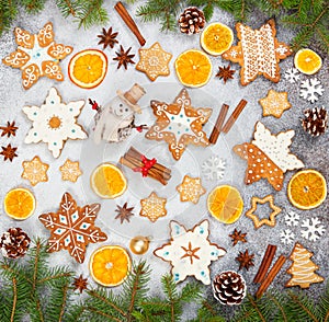 Christmas ginger cookies in the shape snowflakes, dried orange, star anise and snowman on gray stone background