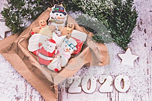 Christmas gingerbread in a box, holiday gift and christmas decorations on wooden background with snow