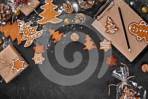 A Christmas gingerbread cookie in the shape of a Christmas tree in a cellophane packing on the background of a dark