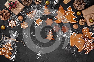 A Christmas gingerbread cookie in the shape of a Christmas tree in a cellophane packing on the background of a dark