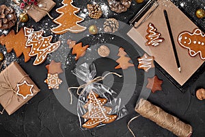 A Christmas gingerbread cookie in the shape of a Christmas tree in a cellophane packing on the background of a dark