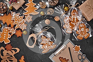 A Christmas gingerbread cookie in the shape of a Christmas tree in a cellophane packing on the background of a dark