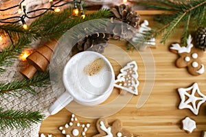 Christmas  gingerbread cookies, coffee, pine cones, fir branches and warm lights on wooden table