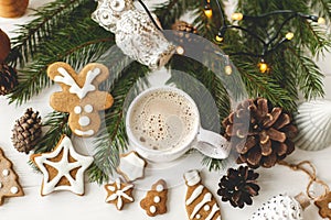 Christmas gingerbread cookies, coffee in stylish  cup, pine cones white wooden table, top view