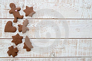 Christmas gingerbread cookies with different shapes over a white vintage wooden table