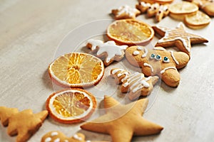 Christmas gingerbread cookies and dried orange and spices on white table