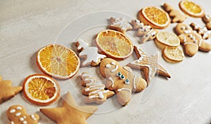 Christmas gingerbread cookies and dried orange and spices on white table