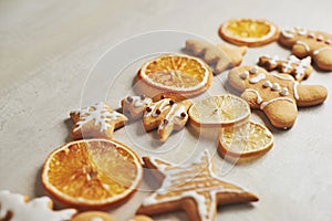 Christmas gingerbread cookies and dried orange and spices on white table