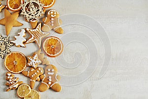 Christmas gingerbread cookies and dried orange and spices on white table