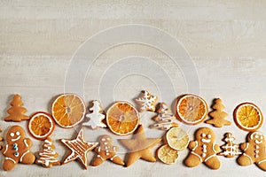Christmas gingerbread cookies and dried orange and spices on white table