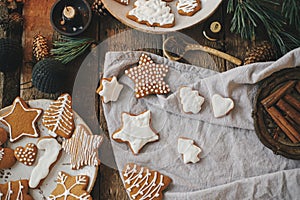 Christmas gingerbread cookies on rustic table with napkin, candle, decorations, spices. Flat lay. Atmospheric moody image. Stylish