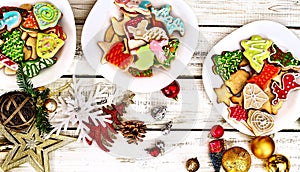 Christmas gingerbread cookies on three plates by wooden table