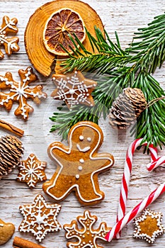 Christmas gingerbread and sweets are placed on wooden desk. Cookies and sweet food in shape of stars and snow flakes. Winter theme