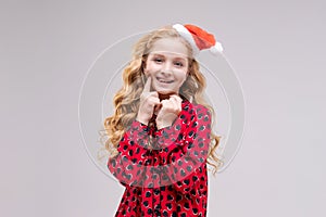 Christmas girl. Beautiful teen model in santa hat isolated on background