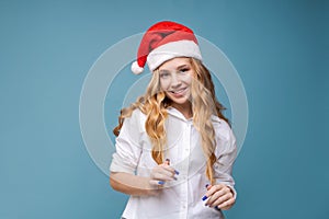 Christmas girl. Beautiful teen model in santa hat isolated on background
