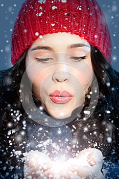 Christmas girl blowing snow in hands
