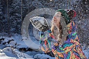 Christmas girl outdoor portrait. Winter woman blowing snow in a park