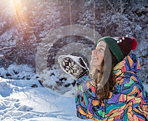 Christmas girl outdoor portrait. Winter woman blowing snow in a park