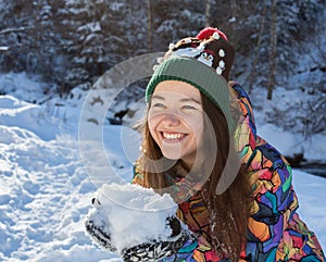 Christmas girl outdoor portrait. Winter woman blowing snow in a park