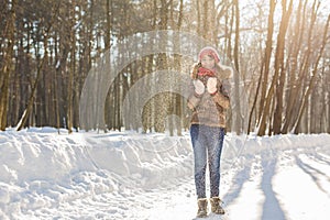 Christmas girl outdoor portrait. Winter woman blowing snow in a park