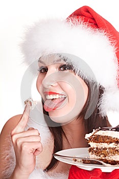 Christmas girl in red santa hat and cake on plate.