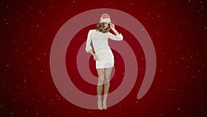 Christmas girl in santa hat dancing happy laughing having fun on red background with snow