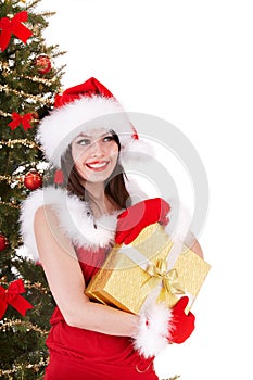 Christmas girl in santa hat with gift box. Tree.