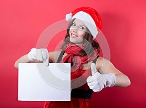 Christmas girl in santa hat holding banner.