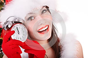 Christmas girl in santa hat holding clock.