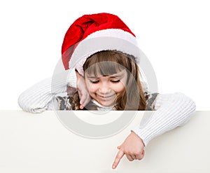 Christmas girl with santa hat standing behind white board.
