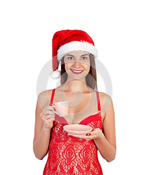 Christmas girl on swimsuit drinking hot tea or coffee. emotional woman in red santa claus hat isolated on white background. Happy