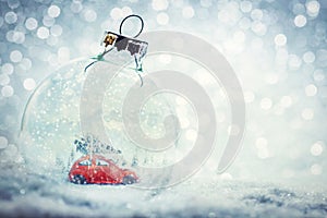 Christmas glass ball in snow with miniature winter world inside