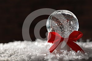 Christmas glass globe with artificial snow on blurred background