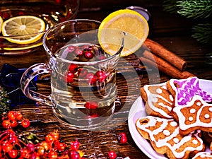 Christmas glass latte mug with lemon and cookies on plate.