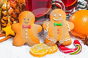 Christmas glass of red mulled wine on table with cinnamon sticks, branches of Christmas tree, snow,