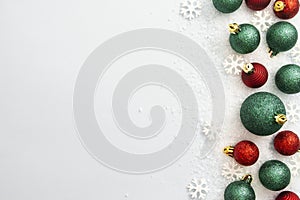 Christmas glitered green and red baubles, balls isolated on snow. Winter abstract border mockup.