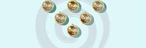 Christmas gold baubles organized on blue background. Top view. Flat lay. Creative New year pattern. Party time concept