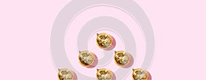 Christmas gold baubles organized on pink background. Top view. Flat lay. Creative New year pattern. Party time concept