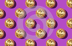 Christmas gold baubles organized on violet background. Top view. Flat lay. Creative New year pattern. Party time concept. Banner