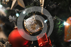 Christmas gold Drum hanging on a beautiful Christmas tree close view and macro