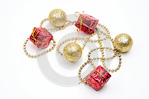 Christmas golden balls and gifts in red packaging tied by a chain on a white background