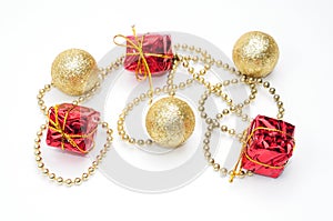 Christmas golden balls and gifts in red packaging tied by a chain on a white background